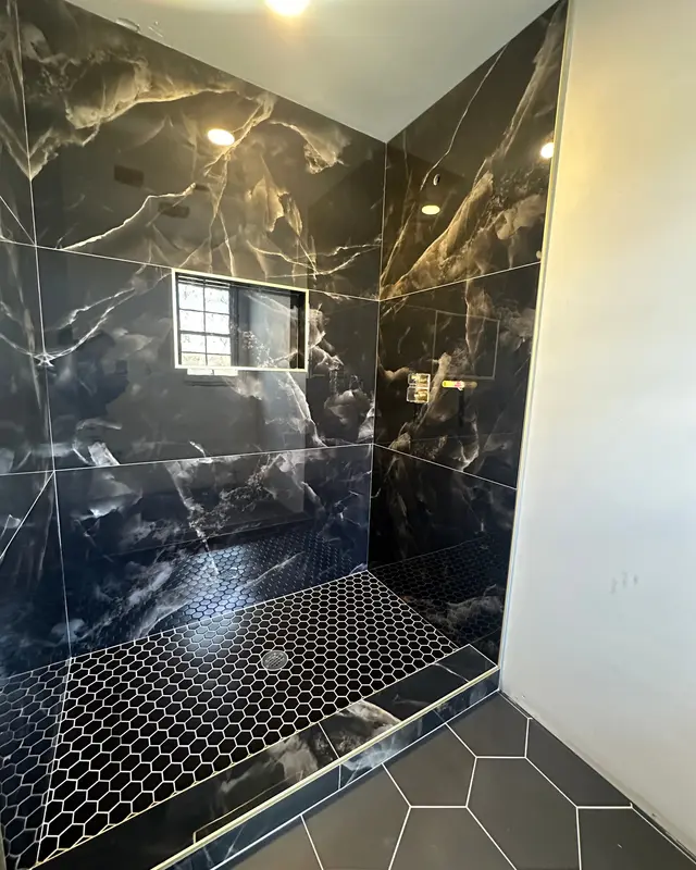 Black onyx-look porcelain shower with gold veining and hex mosaic floor, Atlanta