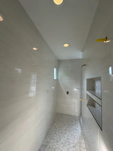 Polished white porcelain shower with floating shelves, Atlanta GA