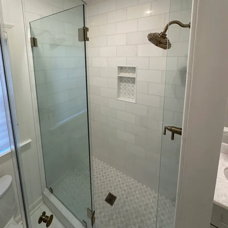 White shower with brass fixtures and marble niche, Atlanta GA