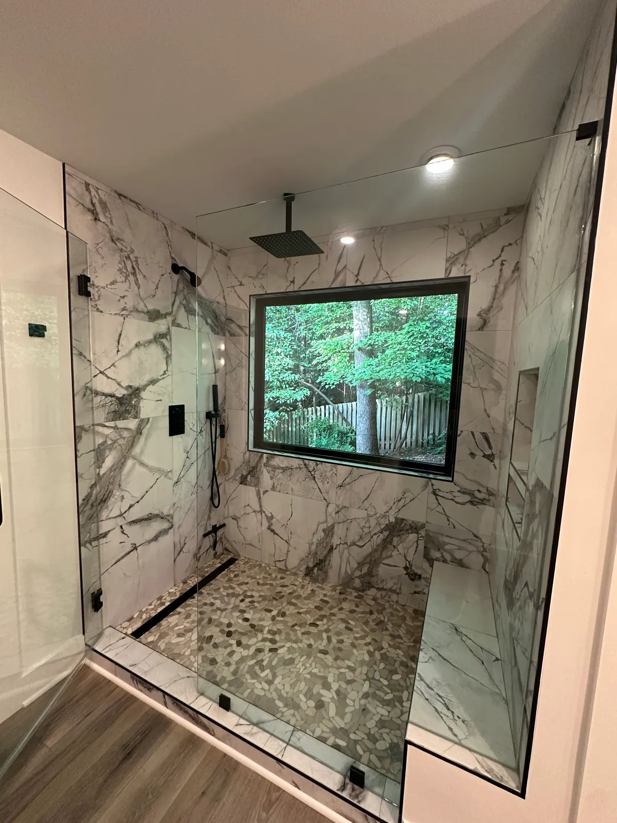 Dramatic marble-look shower with forest picture window, Atlanta GA