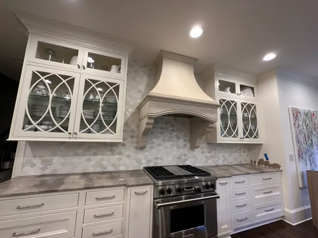 Marble hex mosaic backsplash under a custom kitchen hood