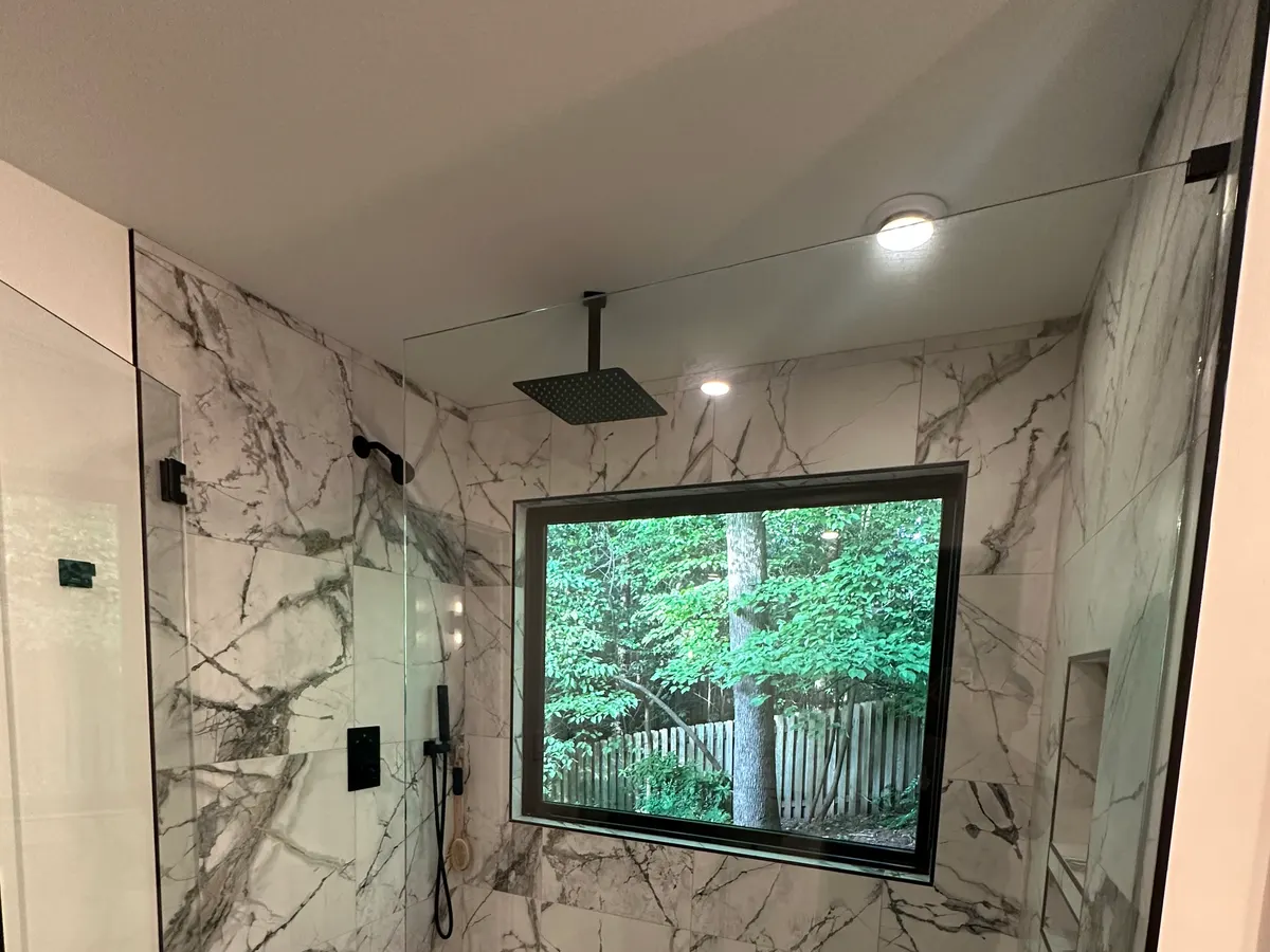 Marble-look walk-in shower with a picture window, set in Atlanta