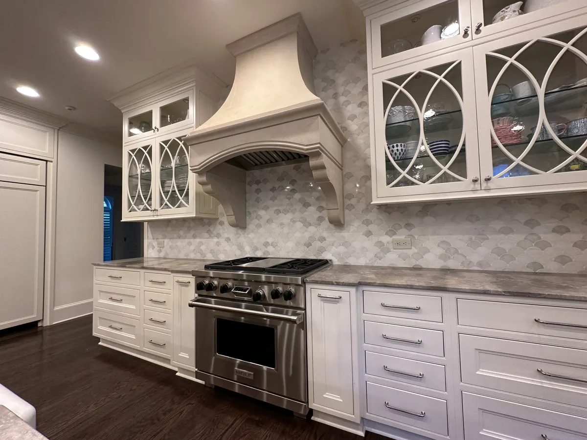 Fish-scale marble mosaic backsplash over a professional range
